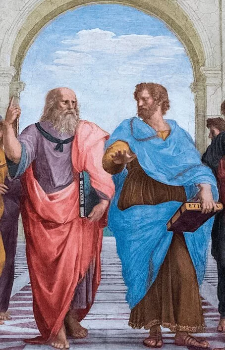 Detalhe do afresco A Escola de Atenas, de Rafael (1509–1511). Platão (à esquerda) aponta para o alto, representando sua ênfase no mundo das ideias. Aristóteles (à direita) gesticula com a palma voltada para baixo, indicando sua atenção ao mundo sensível e empírico. Cada um segura um livro com suas principais obras: Platão com o Timeu e Aristóteles com a Ética. A imagem simboliza a diferença fundamental entre suas filosofias.